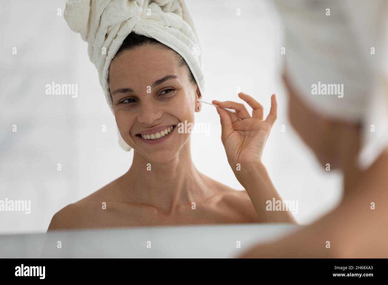 Jeune souriant belle femme hispanique nettoyage des oreilles avec coton-tige. Banque D'Images