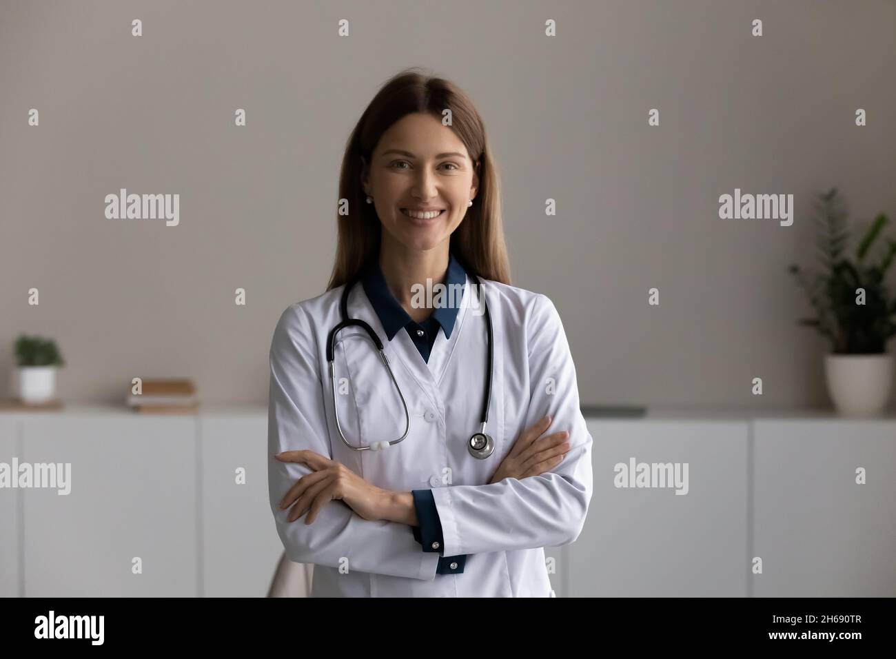 Portrait de la tête souriante femme médecin thérapeute avec les bras croisés Banque D'Images