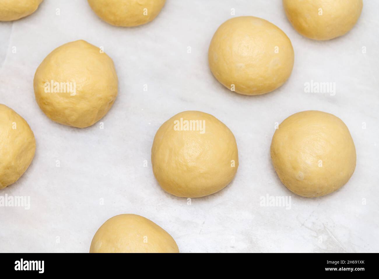 Vue de dessus des boules de pâte crues faites pour cuire des pâtisseries sur du marbre blanc Banque D'Images