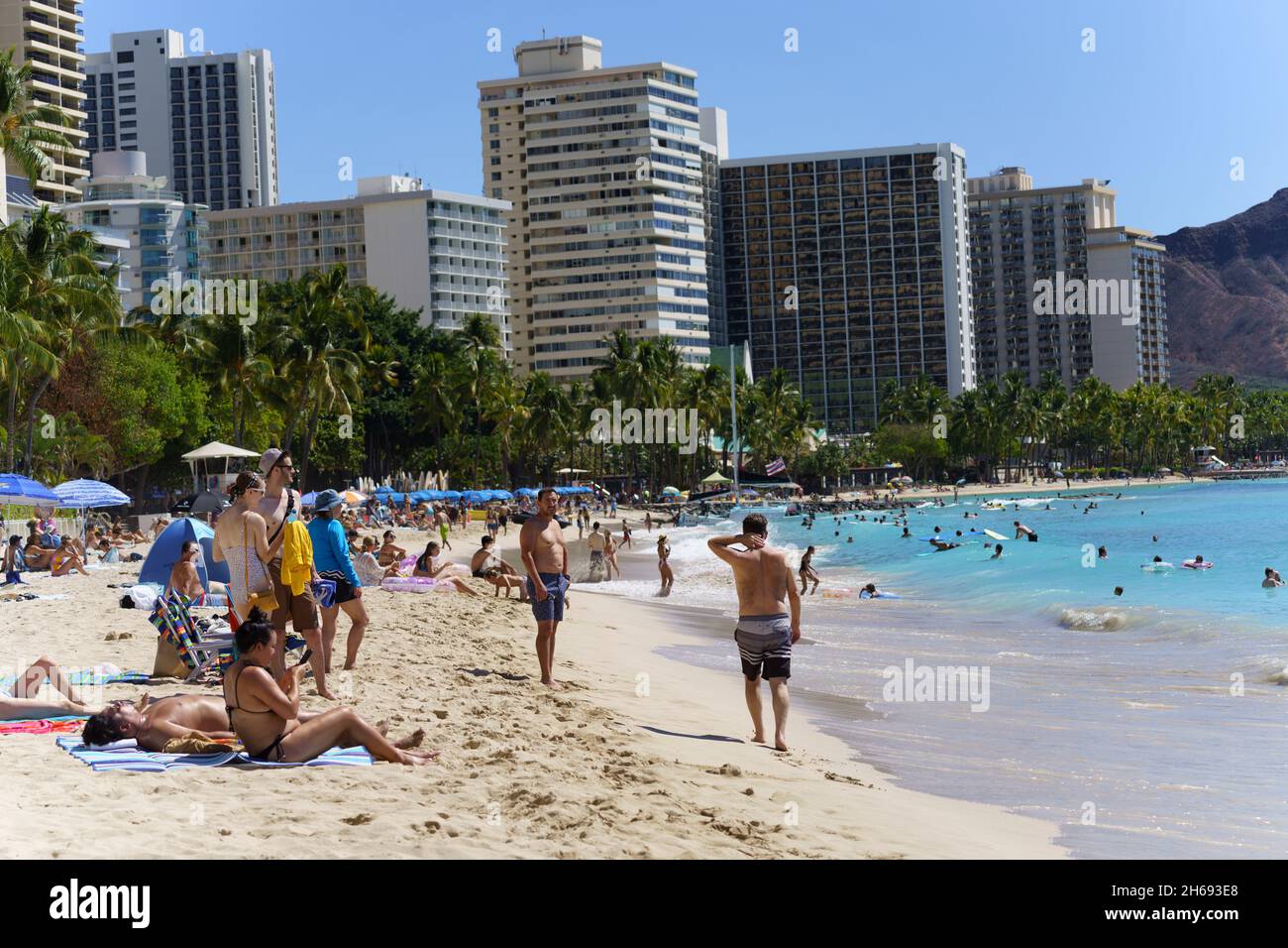 Waikiki, Honolulu, Hawaii - 31 octobre, 2021 familles appréciant la plage en face des hôtels de haute élévation. Banque D'Images