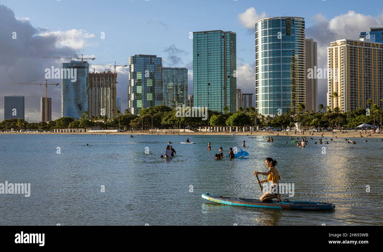 Honolulu, Hawaii - 6 novembre, 2021 personnes jouent dans l'eau en face des gratte-ciel de Waikiki à Honolulu, Hawaï. Banque D'Images