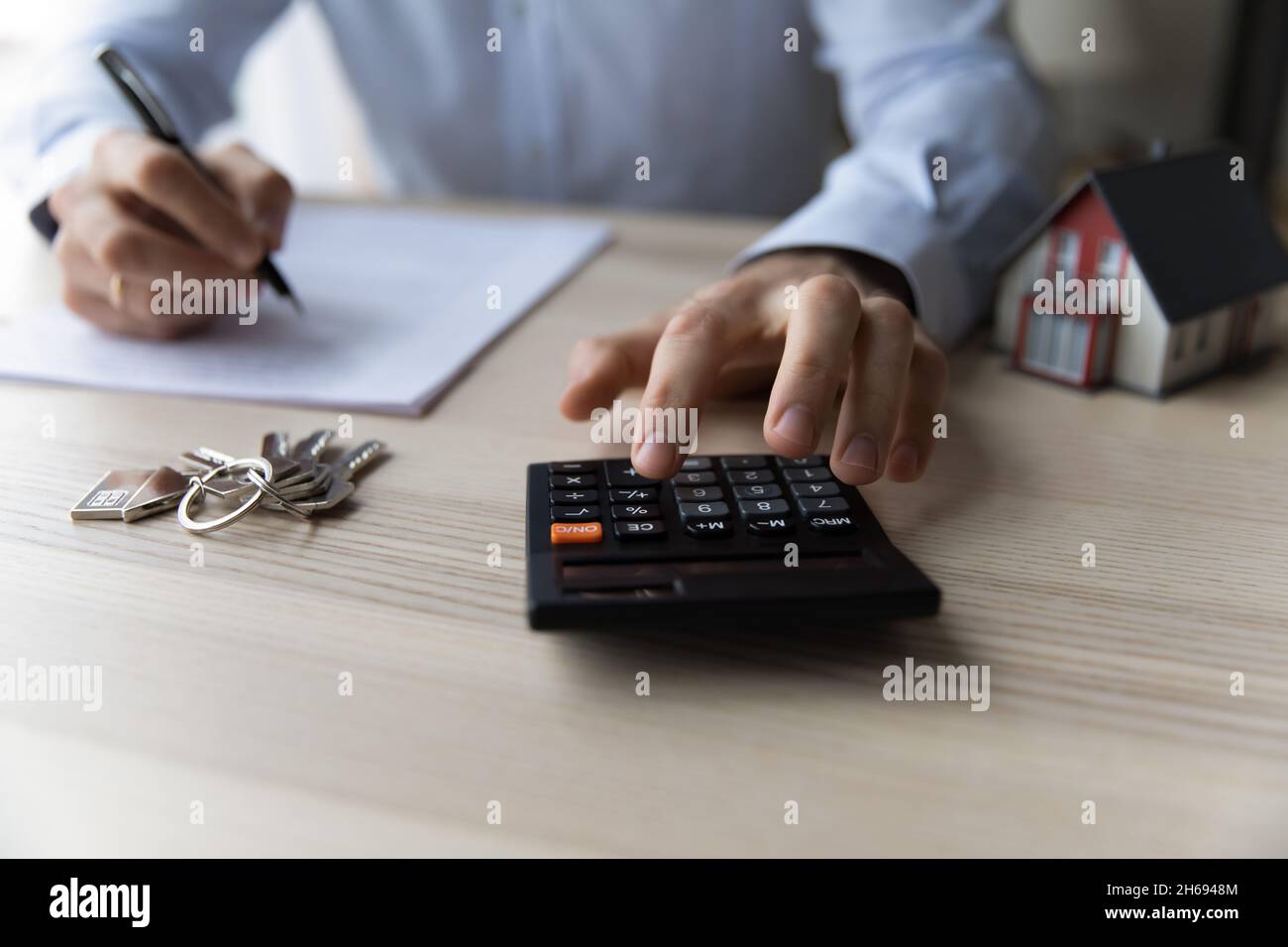 Gros plan jeune homme utilisant la calculatrice, la planification de l'investissement immobilier. Banque D'Images