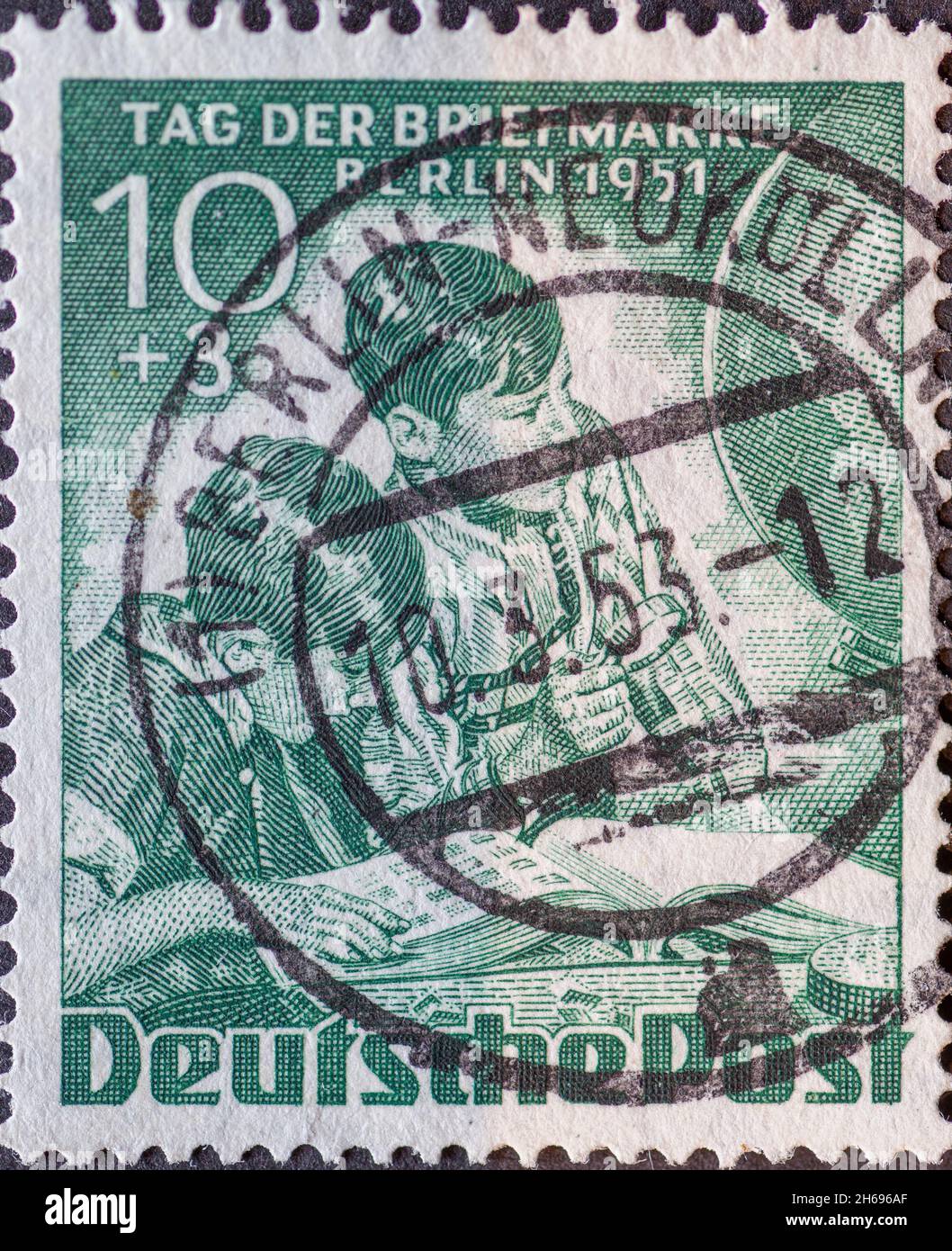 ALLEMAGNE, Berlin - VERS 1951: Timbre-poste de l'Allemagne, Berlin montrant des enfants avec loupe devant l'album de timbre et le monde entier.Colonne Banque D'Images