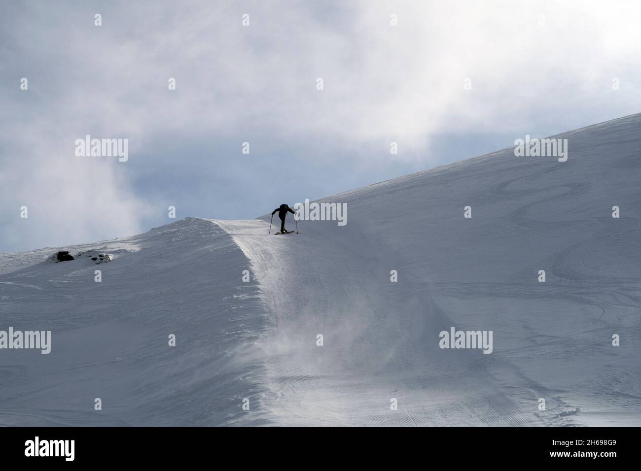 Skieur en montée par beau temps Banque D'Images