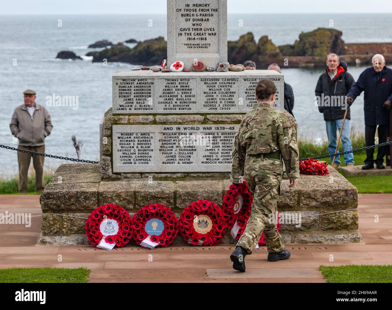 Dunbar, East Lothian, Écosse, Royaume-Uni, 14 novembre 2021.Le jour du souvenir : un service commémoratif au mémorial de guerre et une cérémonie de pose de couronne avec une femme soldat qui pose une couronne de pavot Banque D'Images