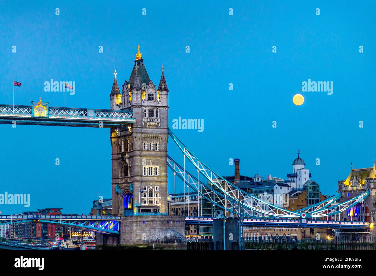 Tower Bridge au-dessus de la Tamise la nuit avec lune en arrière-plan, Londres, Royaume-Uni Banque D'Images