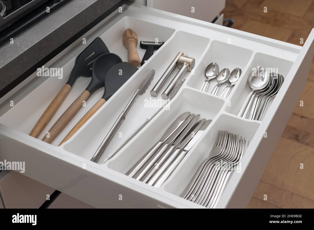 Ouvrez le tiroir avec le jeu d'ustensiles.Rangement de la cuisine Photo  Stock - Alamy