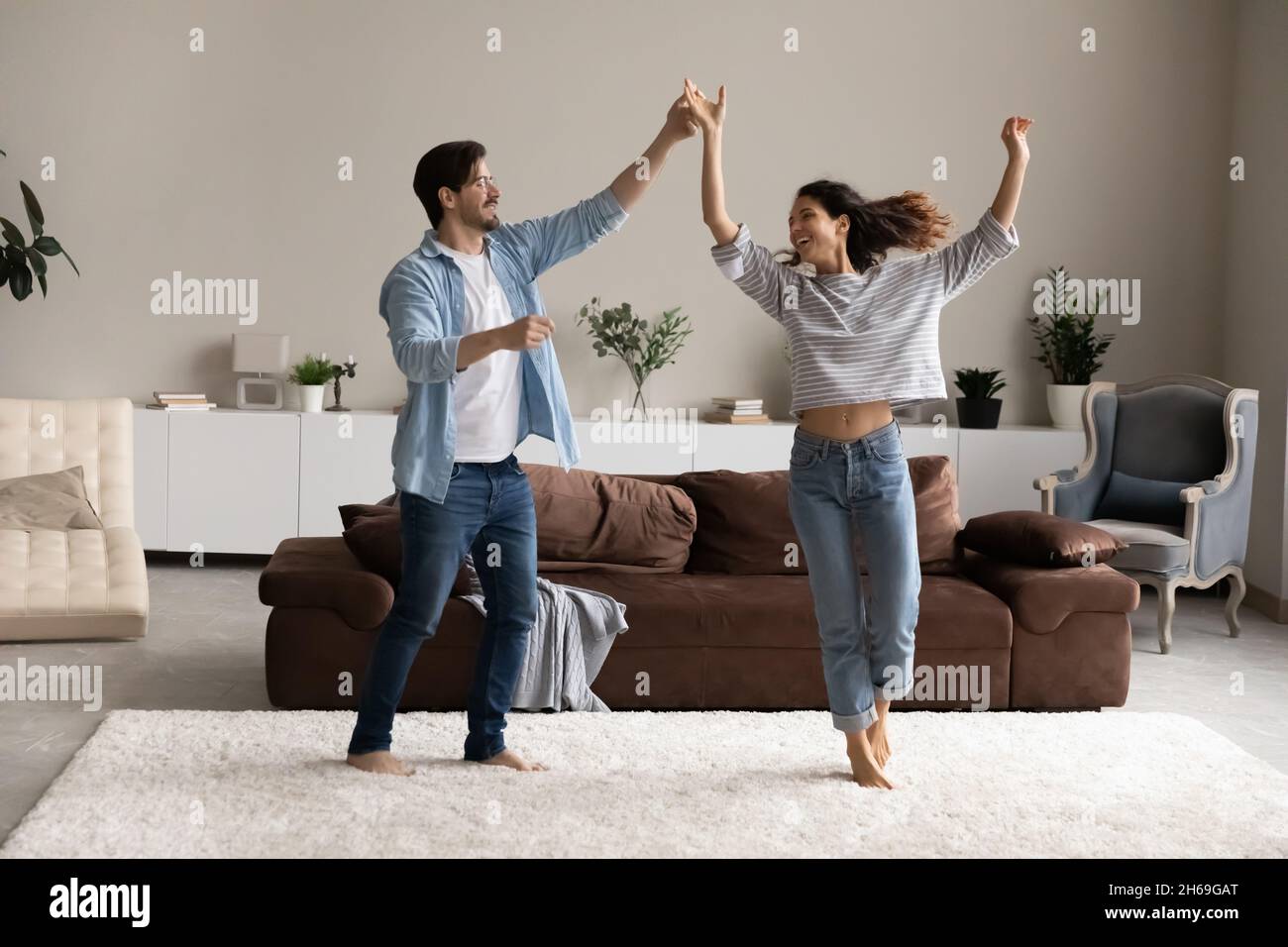 Jeune couple plein d'amour dansant dans le salon ensemble Banque D'Images