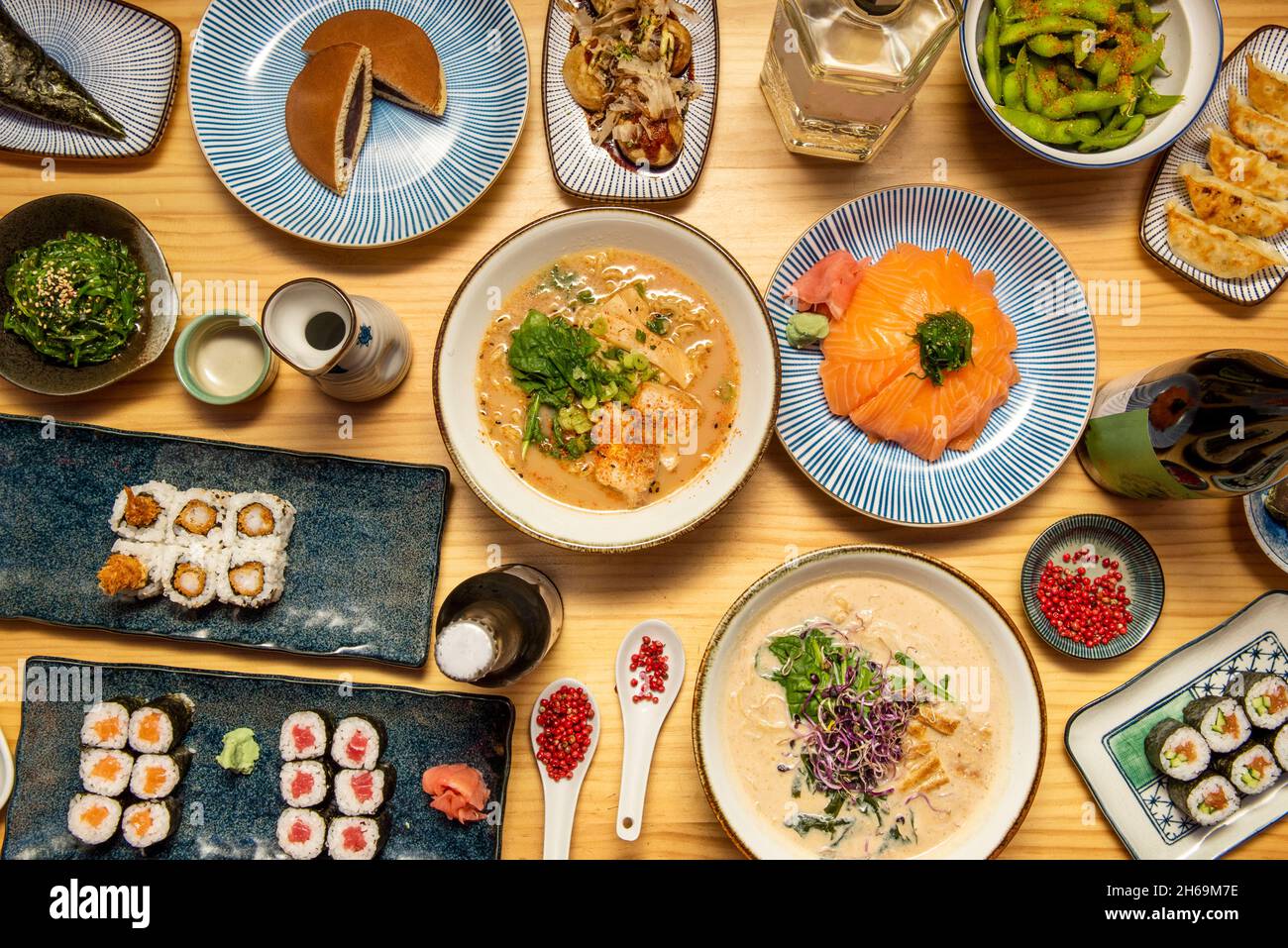 Ensemble de plats japonais, saumon et thon rouge hosomaki, uramaki avec crevettes panées, mochis, miso ramen, salade wakame, poivron rouge,haricots edamame, octop Banque D'Images