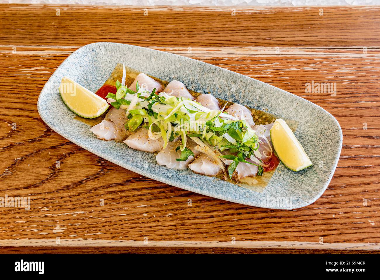 Le sashimi est un plat japonais qui se compose principalement de fruits de mer crus ou de poisson, finement coupés, mais pas autant qu'un carpaccio.Servi avec une sauce et Banque D'Images