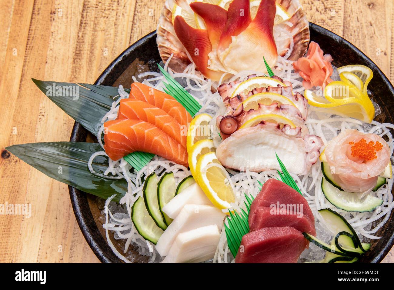Le sashimi est un plat japonais qui se compose principalement de fruits de mer crus ou de poisson, finement coupés, mais pas autant qu'un carpaccio.Servi avec une sauce et Banque D'Images