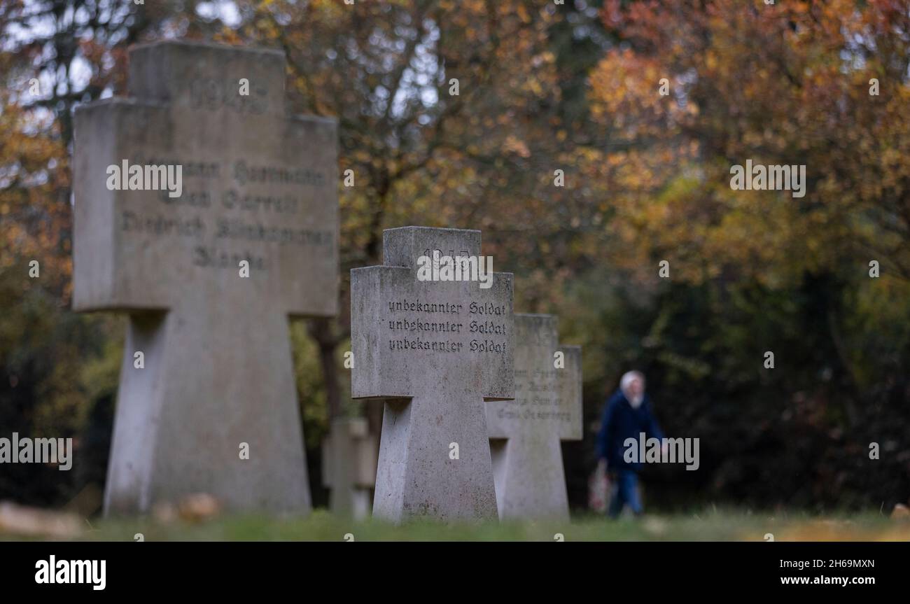 Magdebourg, Allemagne.14 novembre 2021.Une femme passe devant une tombe avec l'inscription « 1945 Soldat inconnu » dans un cimetière militaire du cimetière ouest de Magdebourg.Le jour du souvenir, les victimes de la guerre et de la tyrannie ont été commémorées dans toute la Saxe-Anhalt par des cérémonies de pose de couronnes et des services d'église.Crédit : Ronny Hartmann/dpa/Alay Live News Banque D'Images