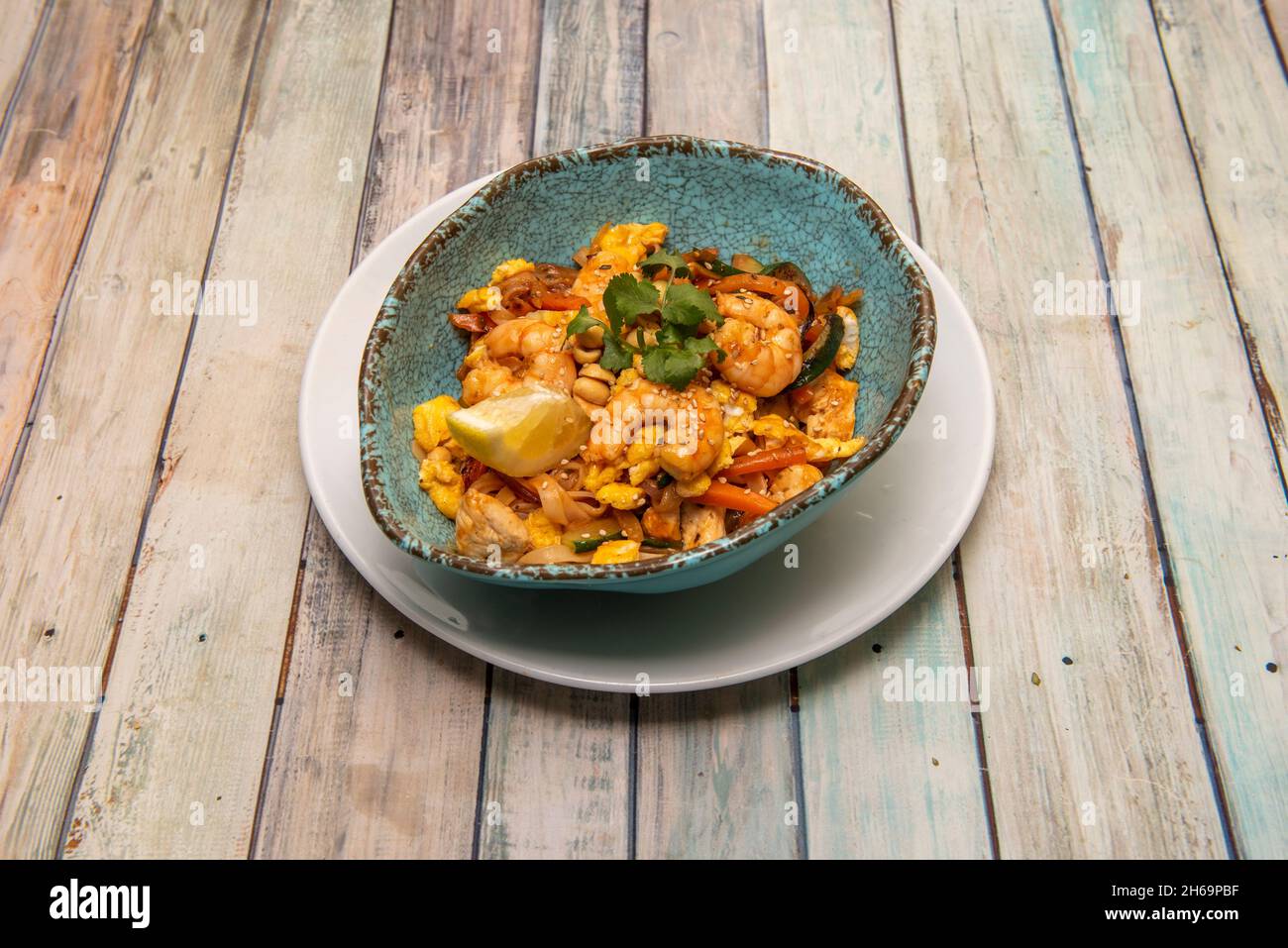 Tampon thaï, nouilles de riz, sauce de poisson, pâte de tamarin, poivron rouge,pousses de haricots, crevettes, poulet aux arachides et à la coriandre hachées, coin de citron, banane Banque D'Images