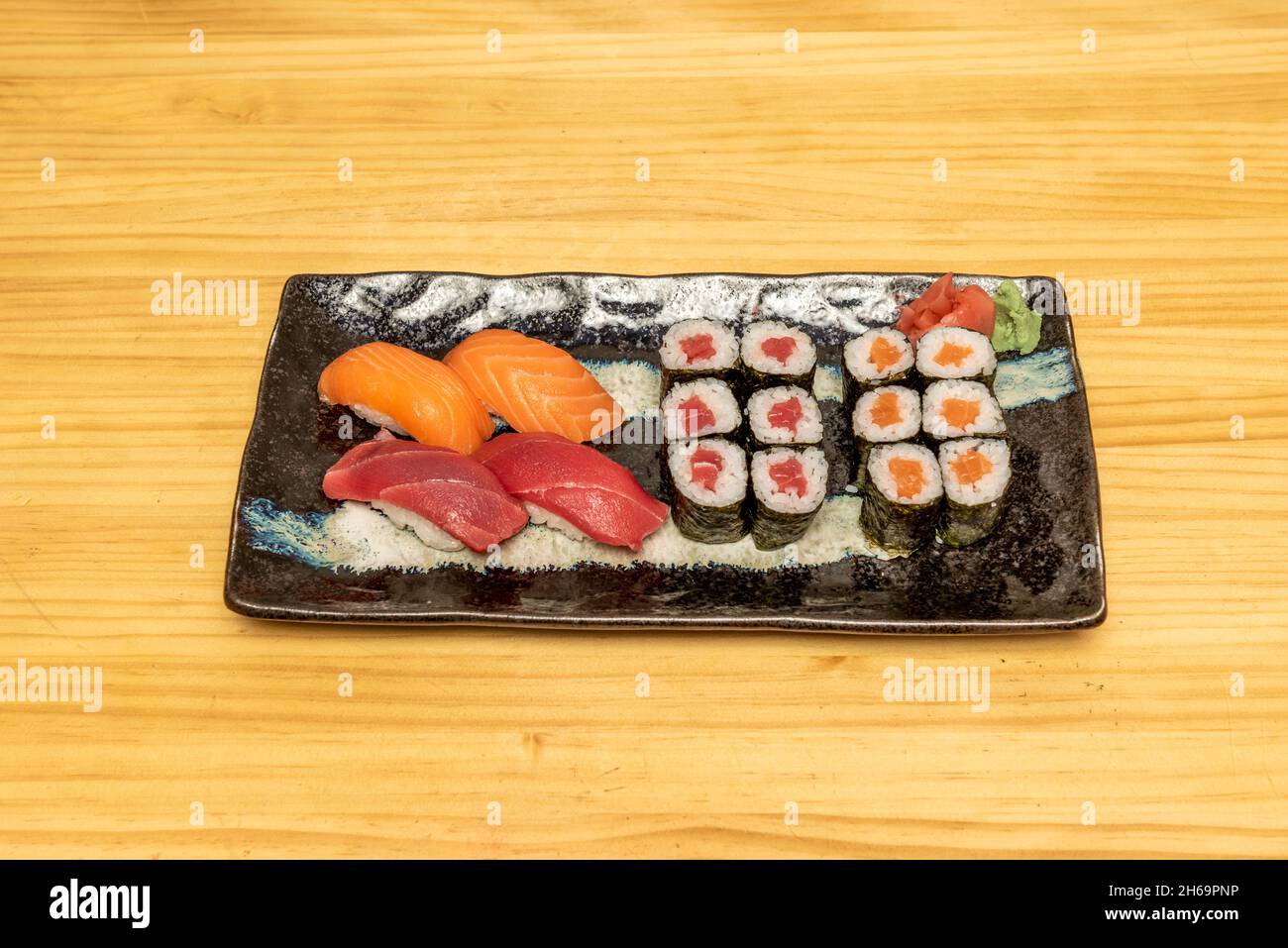 Plateau de sushis mélangés avec nigiri de saumon norvégien et thon rouge et maki avec riz et vinaigre japonais, algues nori, wasabi en conserve avec gingembre Banque D'Images