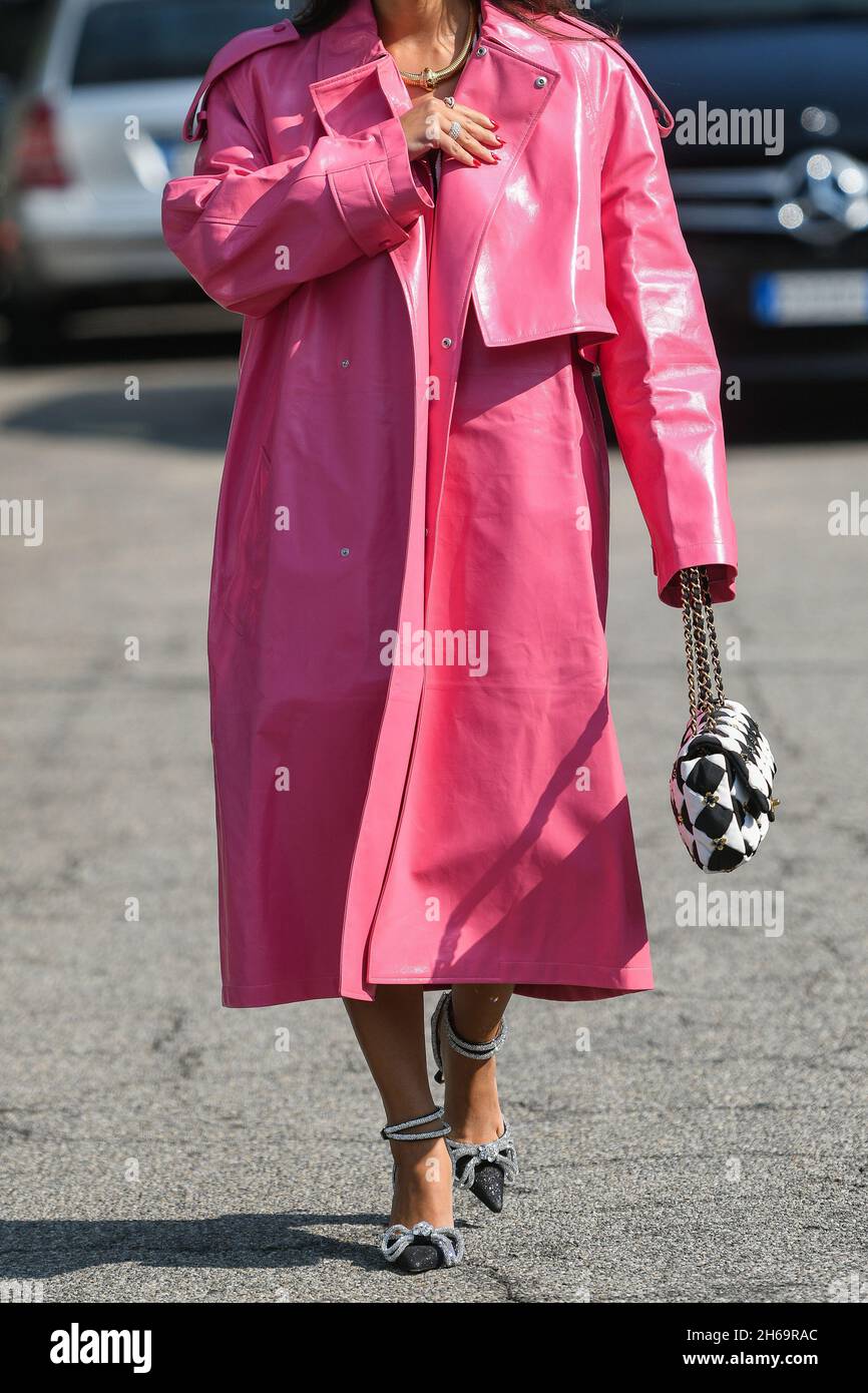 Milan, Italie - 24 septembre 2021: Tenue de style de rue, femme à la mode portant un long manteau rose, un sac à main à carreaux noir et blanc de Chanel, b Banque D'Images