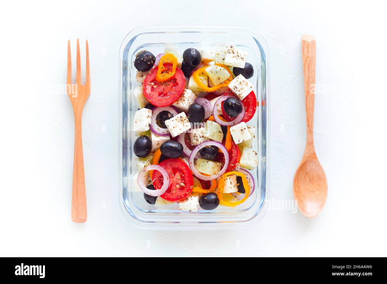 contenant avec salade grecque, coutellerie en bois, sur fond blanc, vue de dessus, concept de nourriture saine et zéro déchet Banque D'Images