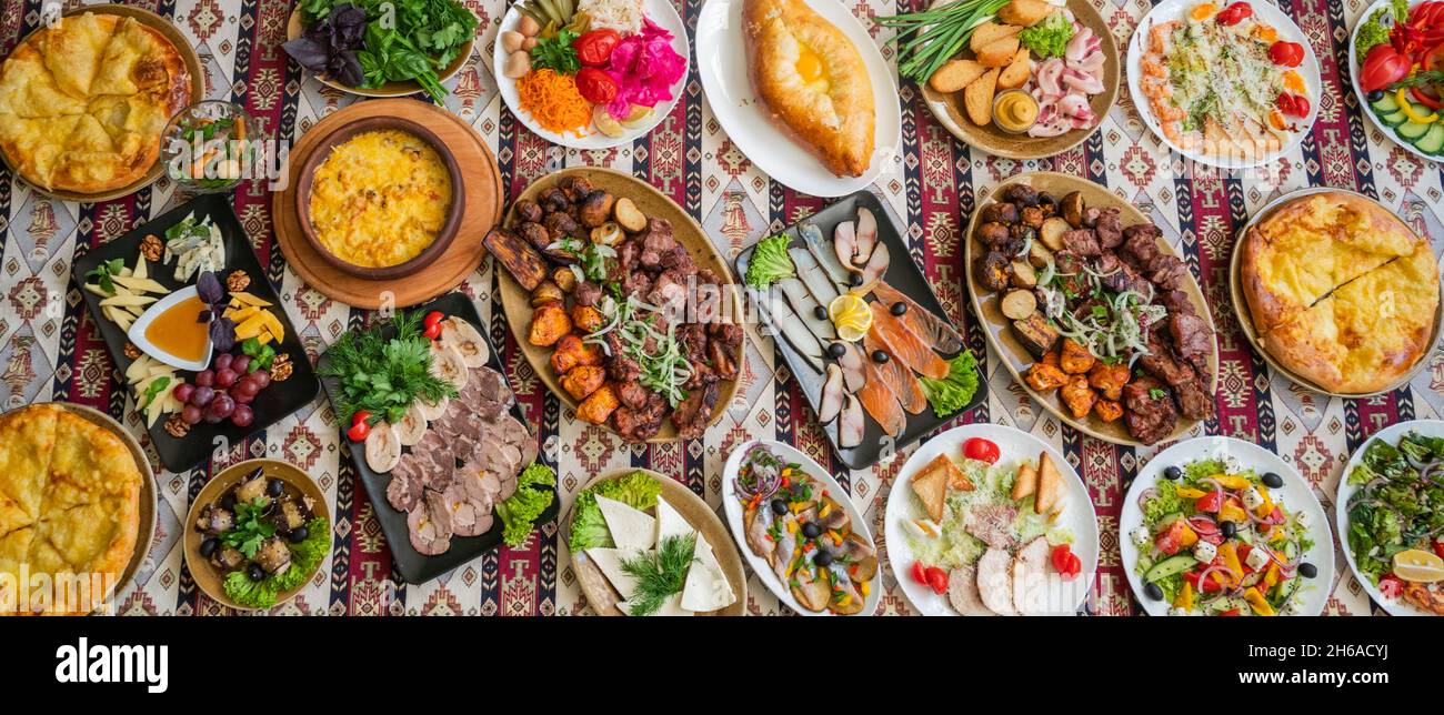 panorama de la cuisine nationale géorgienne et azerbaïdjanaise, des plats de khachapuri cuits au suluguni, des champignons et des légumes et des herbes avec une assiette de chees assortis Banque D'Images