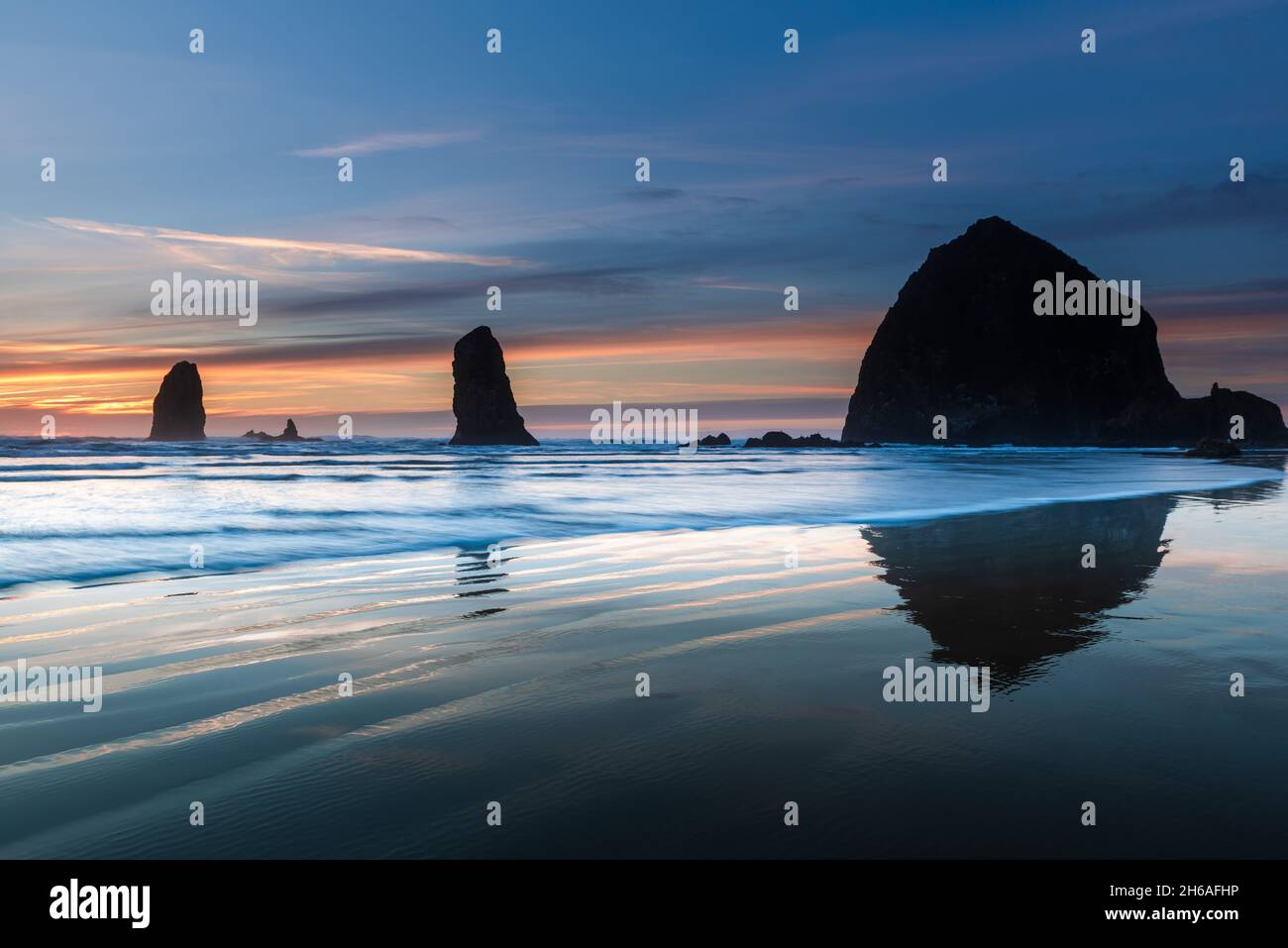 Vagues devant Cannon Beach haystack à l'heure bleue Banque D'Images