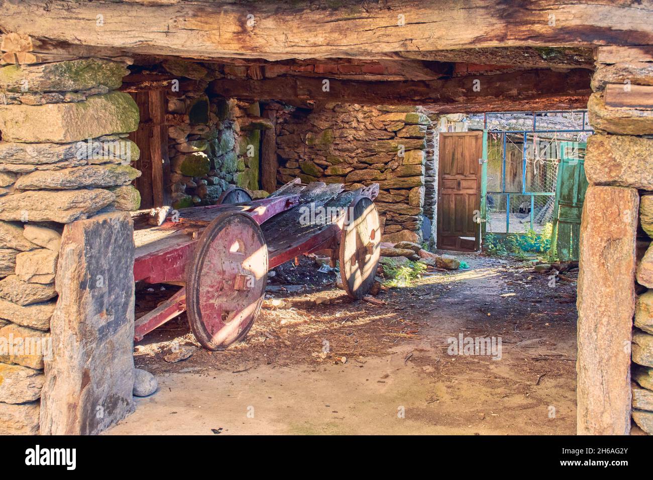 Une vieille voiture se trouve dans un ancien bâtiment avec des portes ouvertes. Banque D'Images