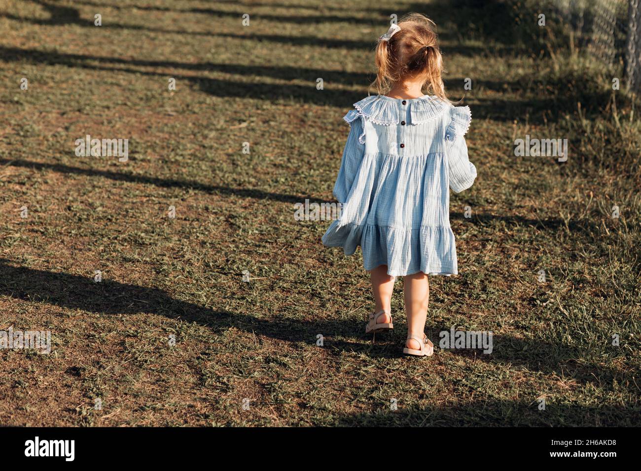 une fille de 3 ans marche à la ferme.Vêtements pour enfants en matériaux naturels.Bonne enfance.Enfant.Industrie agricole.Agrotourisme.Unité avec nat Banque D'Images