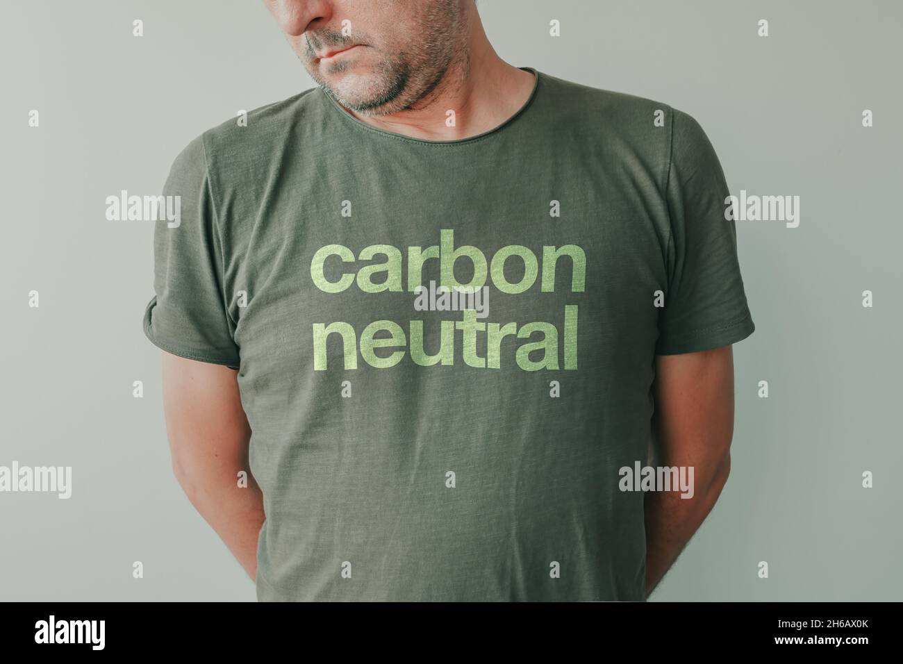 Homme portant un t-shirt vert avec texte neutre en carbone, portrait d'écologiste et activiste environnemental Banque D'Images