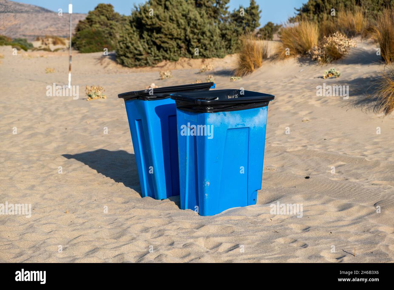 Maintenez le concept de sensibilisation à l'environnement de la plage propre.De grandes poubelles bleues au milieu de la côte sablonneuse.Poubelles bennes bennes bennes bennes de bennes sur le san doux Banque D'Images