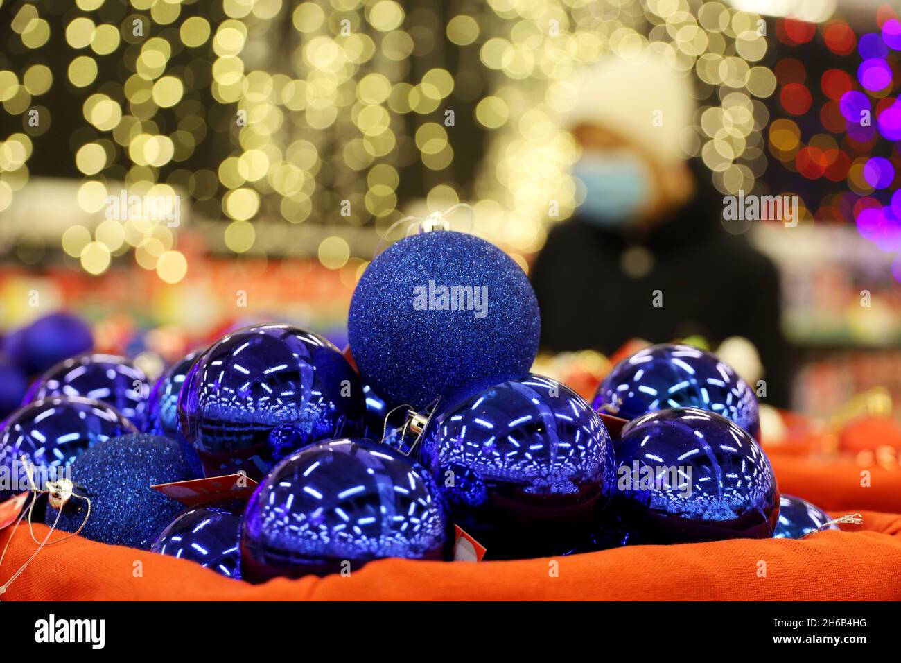 Jouets de Noël, boules bleues dans un panier.Décorations du nouvel an dans un supermarché sur fond de lumières de fête floues Banque D'Images