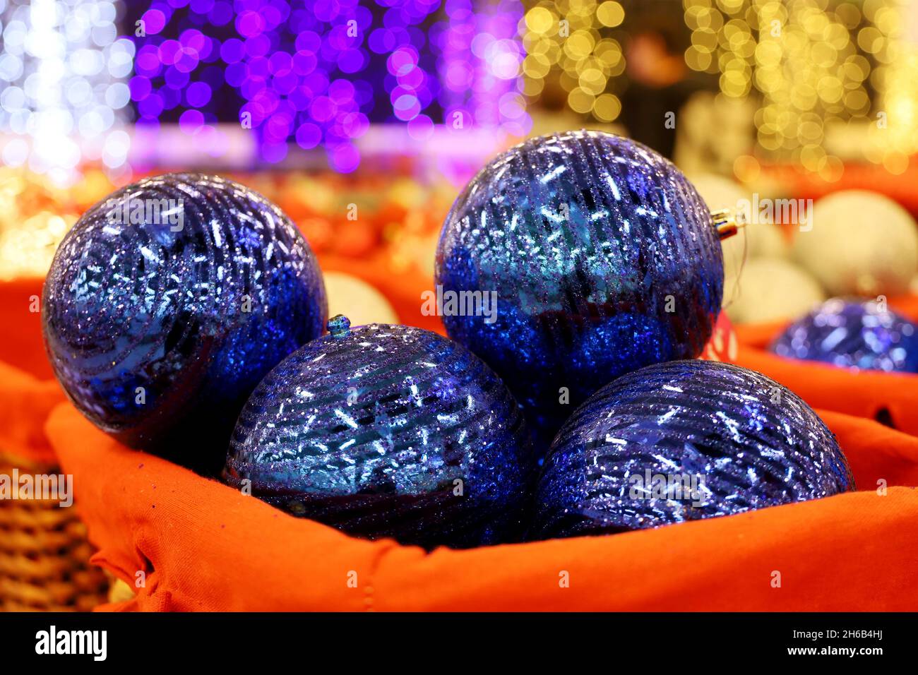 Jouets de Noël, boules bleues dans un panier.Décorations du nouvel an dans un supermarché sur fond de lumières de fête floues Banque D'Images