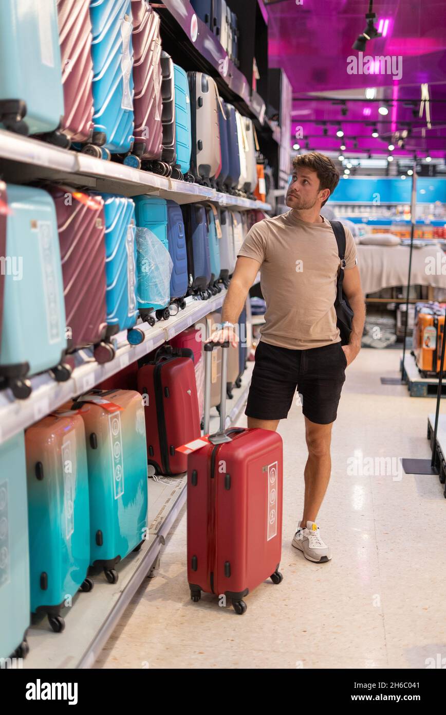 Homme de corps entier inspectant la valise rouge tout en achetant un sac de  voyage dans un magasin contemporain le week-end Photo Stock - Alamy