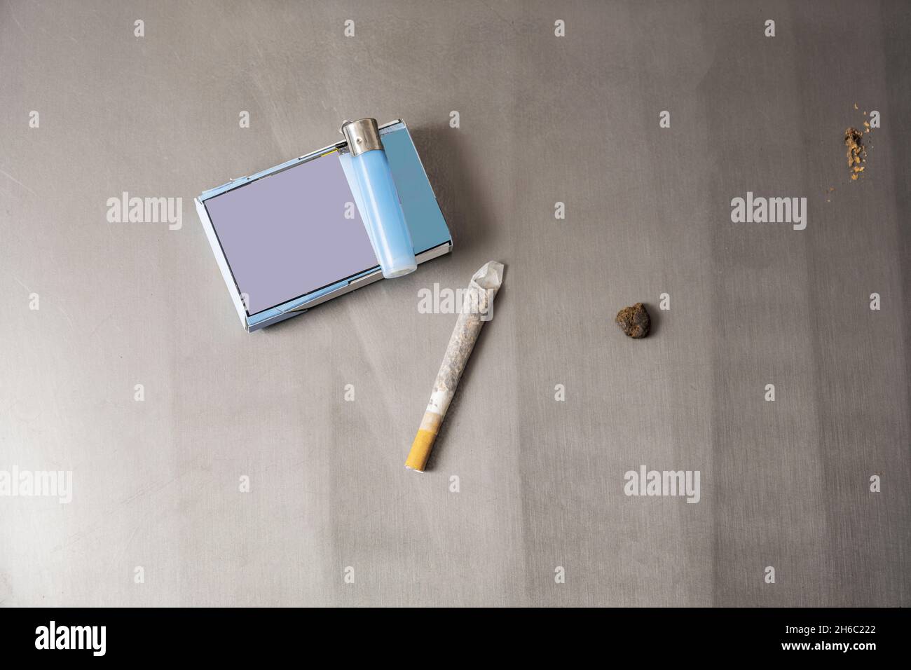 cigarettes à rouler avec briquet, paquet et autres choses sur table grise Banque D'Images