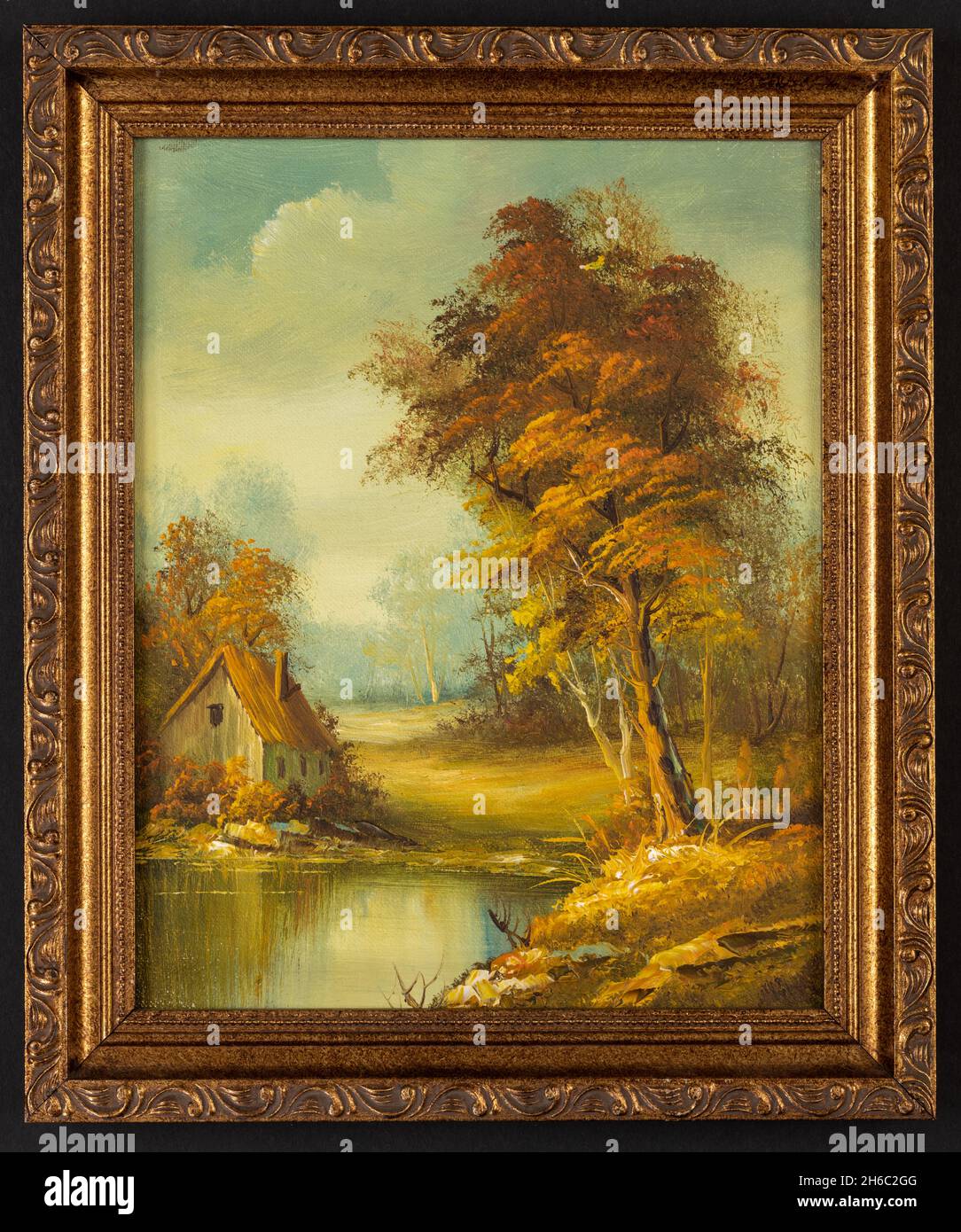 Peinture à l'huile d'époque encadrée représentant une petite cabane près d'un lac et de bois. Banque D'Images