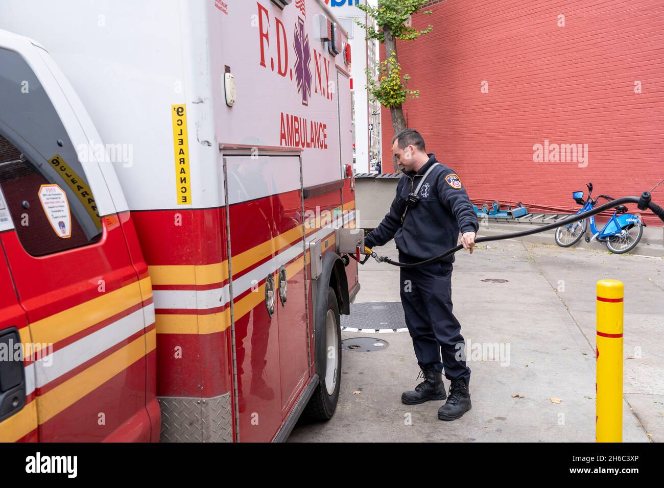 NEW YORK, NY – 14 NOVEMBRE : un technicien médical d'urgence FDNY alimente une ambulance à une station-service mobile le 14 novembre 2021 à New York.Se tenant devant une station-service Mobil sur la 8th Avenue dans West Village, où les prix commencent à $4.33 le gallon pour un gallon d'essence de 87 octane, le sénateur américain Chuck Schumer (D-NY), chef de la majorité au Sénat, a déclaré que les conducteurs de New York ont désespérément besoin d'un soulagement de la hausse des prix du carburant.Le sénateur Schumer espère que puiser dans la réserve pétrolière stratégique du pays contribuera à réduire les coûts du carburant pendant un certain temps. Banque D'Images