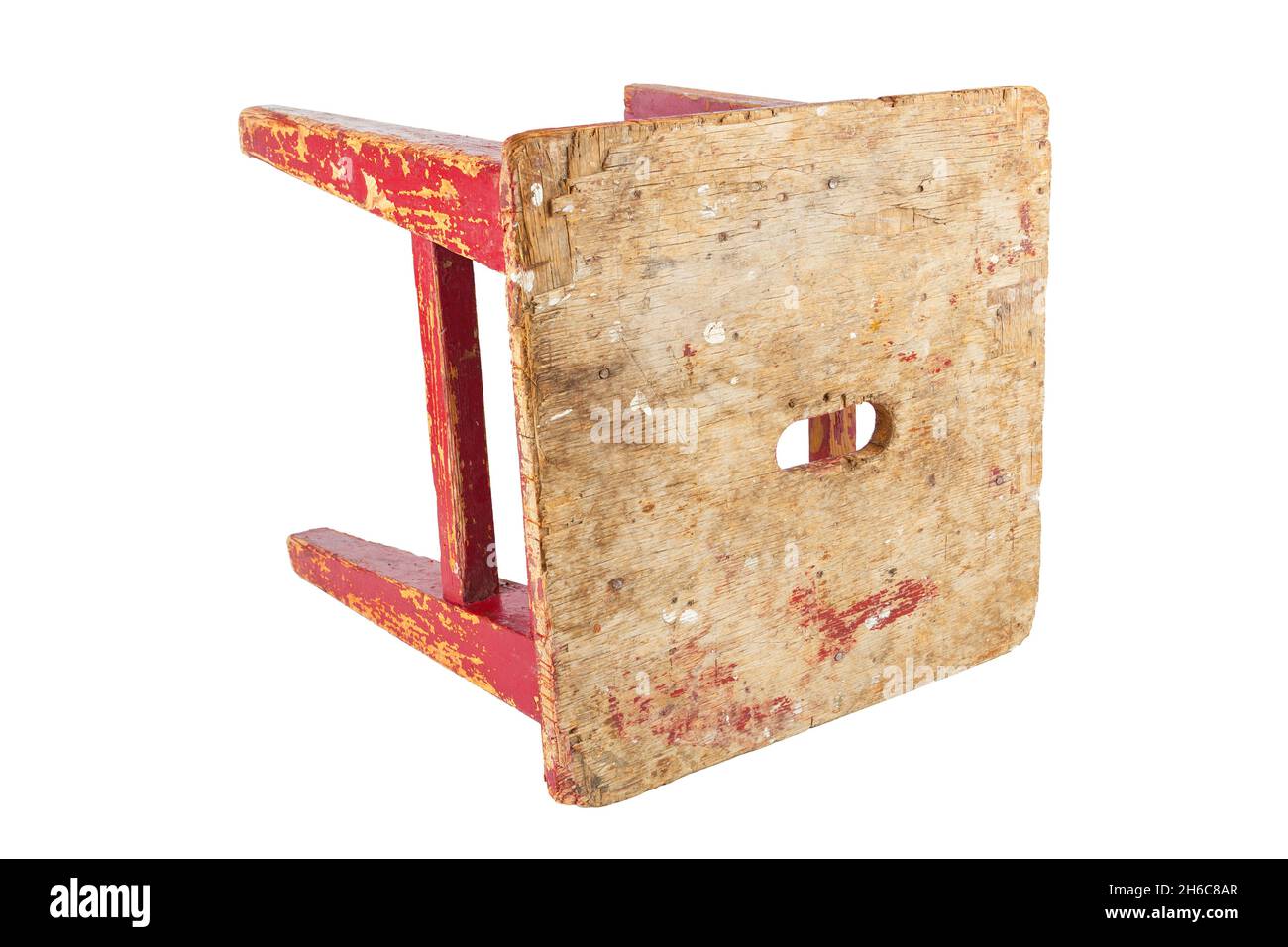 Vieux tabouret en bois avec peinture rouge qui s'écaille.Chaise de style loft isolée sur fond blanc. Banque D'Images