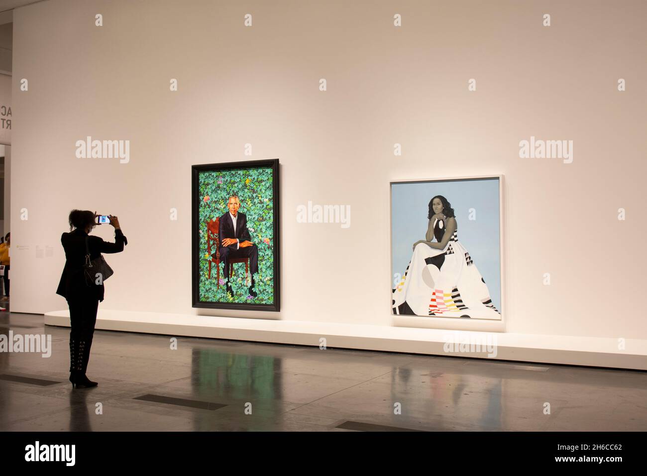 Une femme afro-américaine prenant une photo des portraits officiels de Barack Obama et de Michelle Obama.La 44e Présidente et première Dame. Banque D'Images