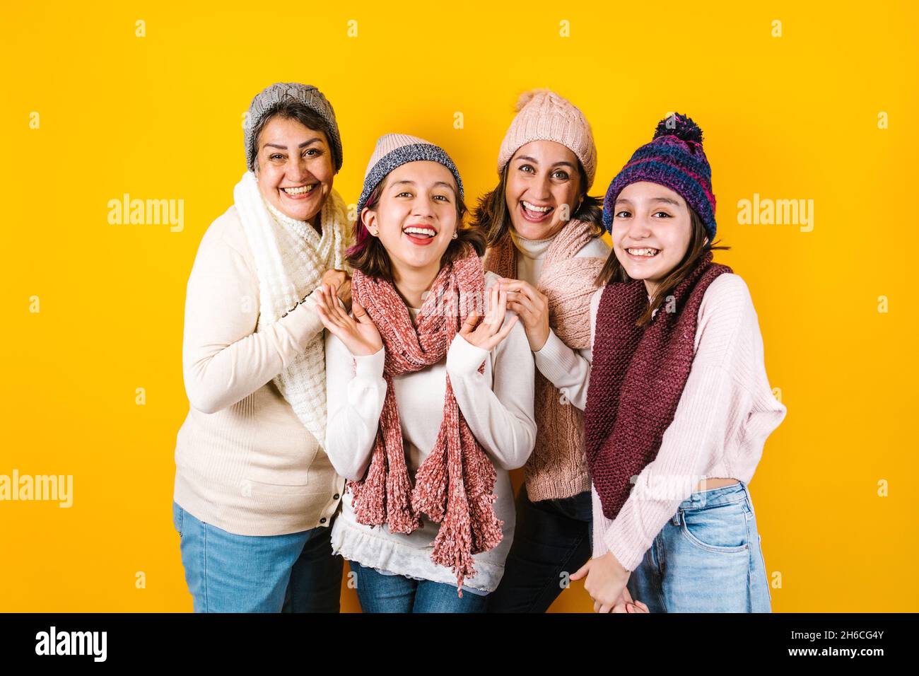 Portrait d'hiver de la famille latine heureuse trois générations de femmes hispaniques sur fond jaune au Mexique Amérique latine Banque D'Images