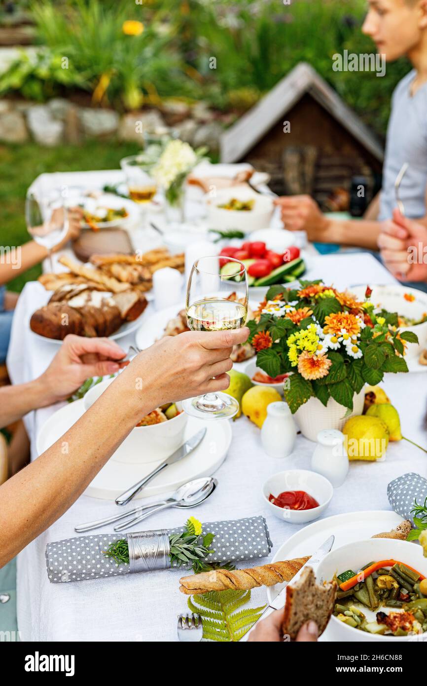 Un dîner de fête en famille ou un barbecue dans le jardin d'été.Loisirs en famille et célébration et concept de nourriture.Les gens mangent dans un jardin.Barbecue, v Banque D'Images