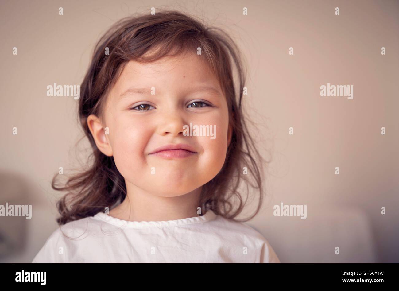 Portrait en gros plan d'une petite fille mignonne souriant - enfant d'âge préscolaire dans un jardin d'enfants Banque D'Images
