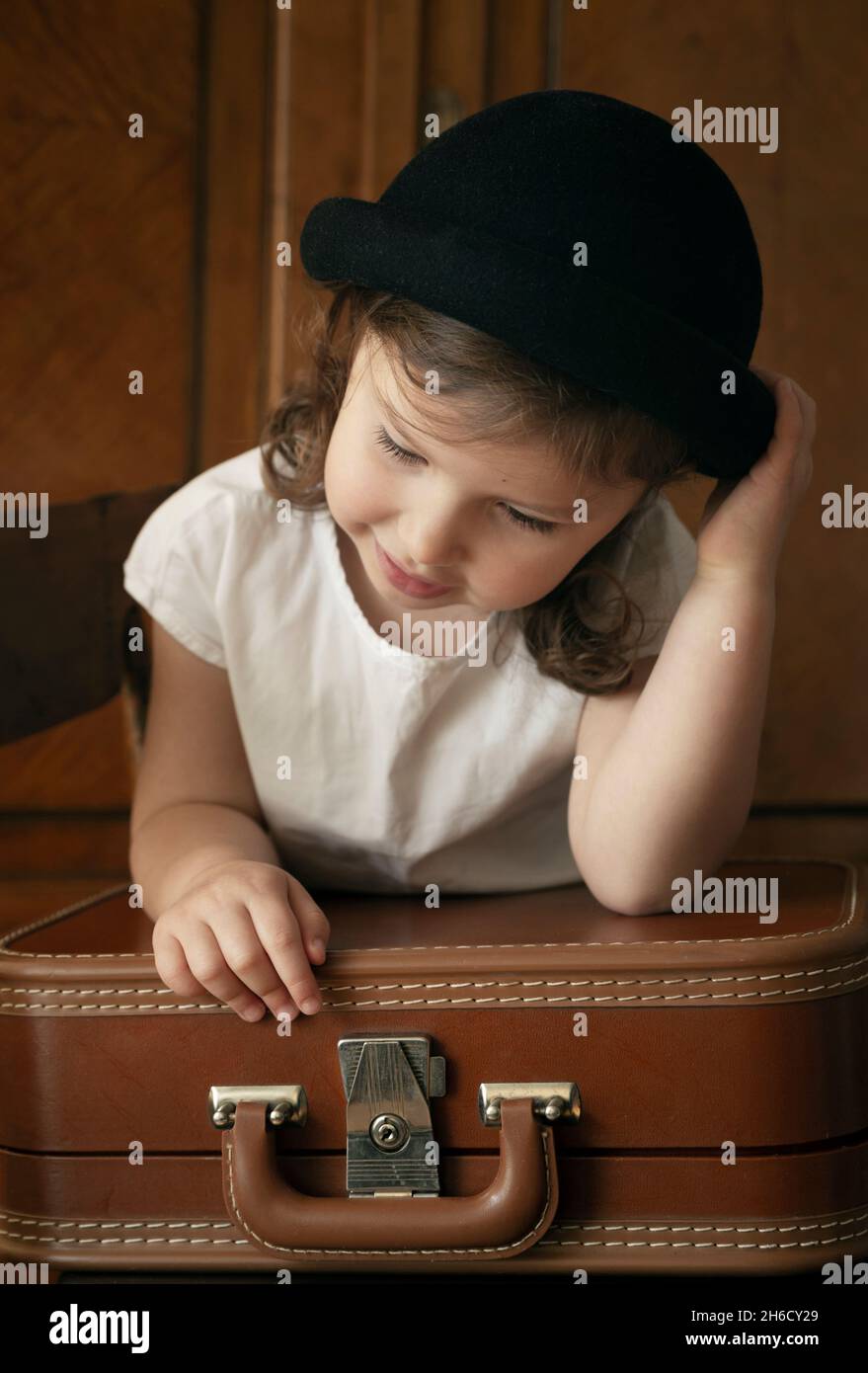 Petite fille mignonne avec une valise vintage se préparer pour le voyage Banque D'Images