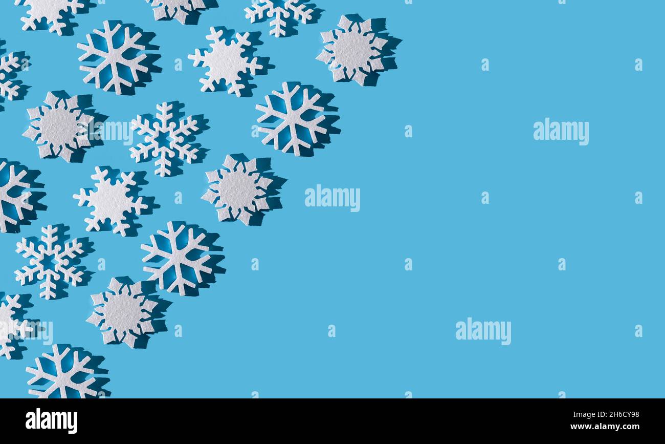 Arrière-plan de Noël.Motif flocon de neige.Flocons de neige blancs sur bleu.Neige.Ambiance hivernale.Abstraction conceptuelle.Flocon de neige en polystyrène.Modèle du nouvel an.Copier l'espace.Texture. Banque D'Images