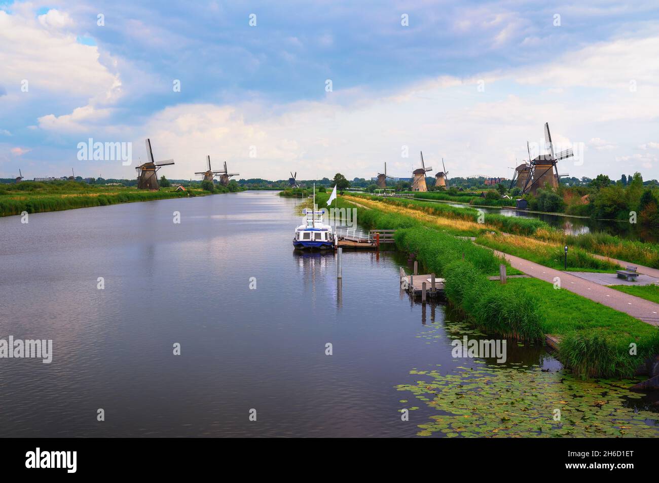 Moulins à vent historiques et rivière avec un bateau à Kinderdijk, pays-Bas Banque D'Images