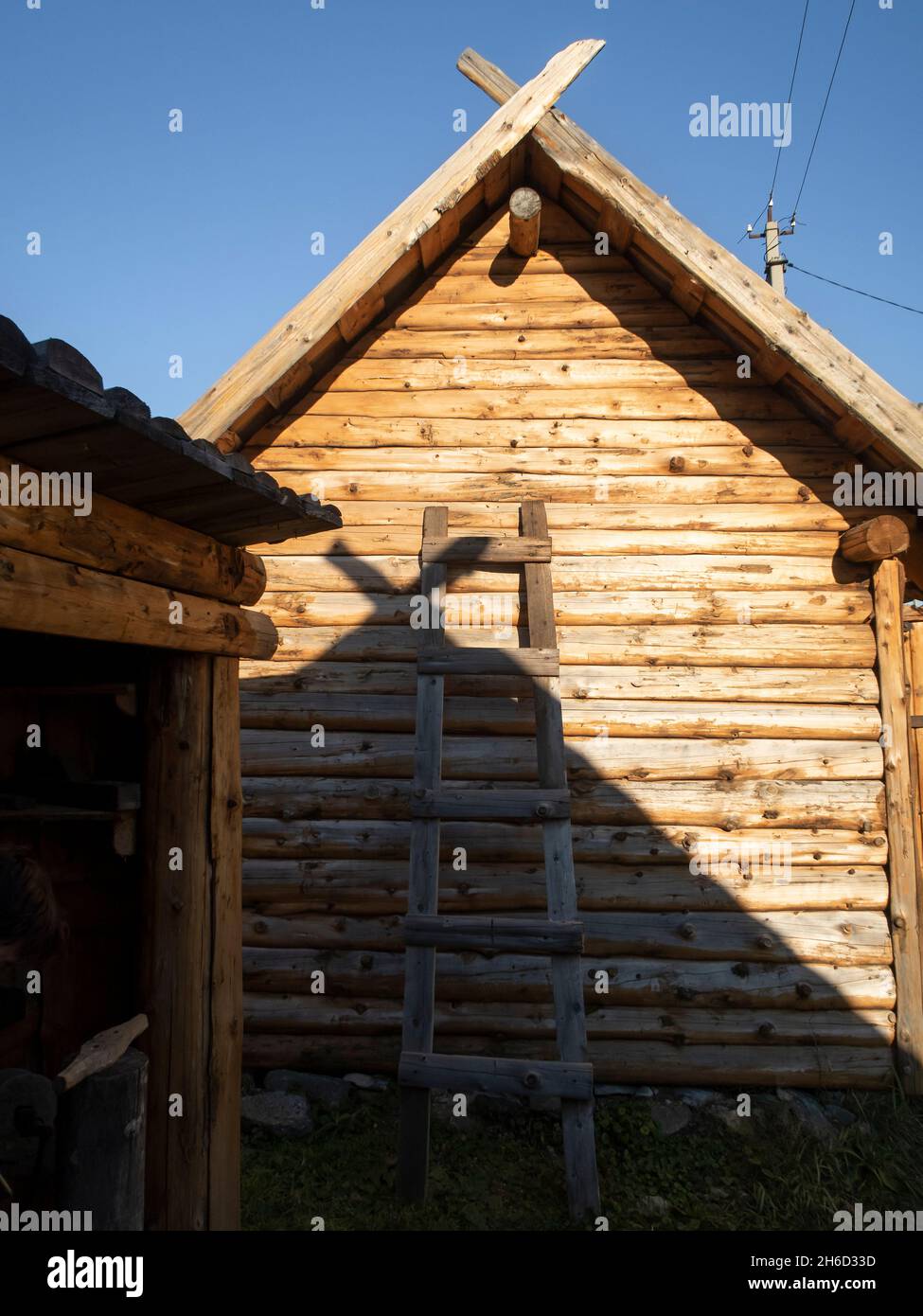 Le mur d'une maison en bois dans le village avec une échelle penchée contre elle Banque D'Images