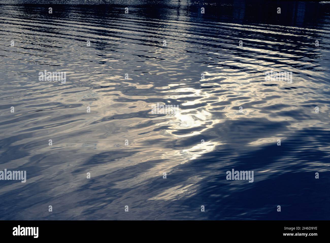 Formes et patrons abstraits et mous causés par la lumière du soleil se reflétant à la surface d'une rivière Banque D'Images