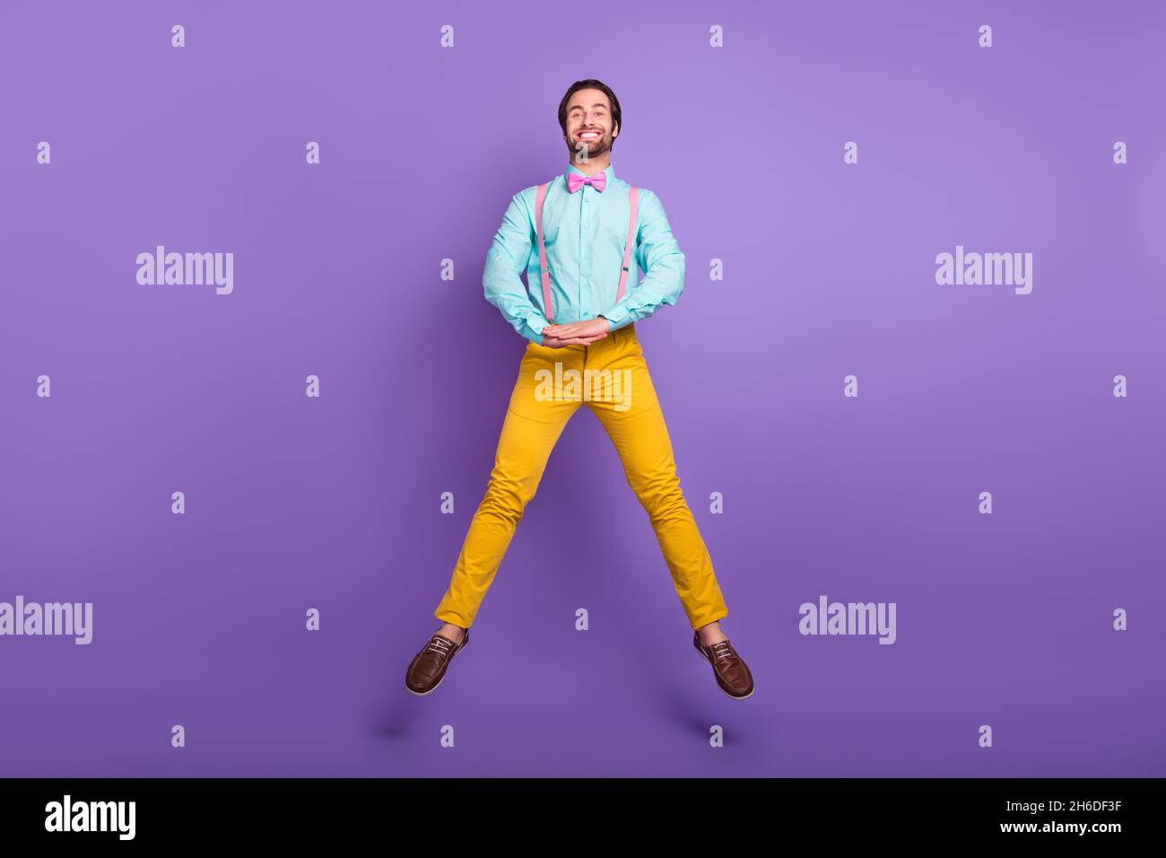 Photo pleine longueur de Nice millenny Guy jump port cravate bretelles chemise pantalon chaussures isolées sur fond violet Banque D'Images