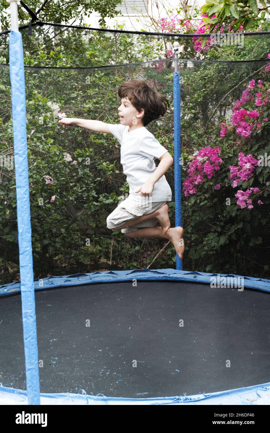 Jeune garçon de six sauts sur un trampoline Outdoor Model sort Banque D'Images