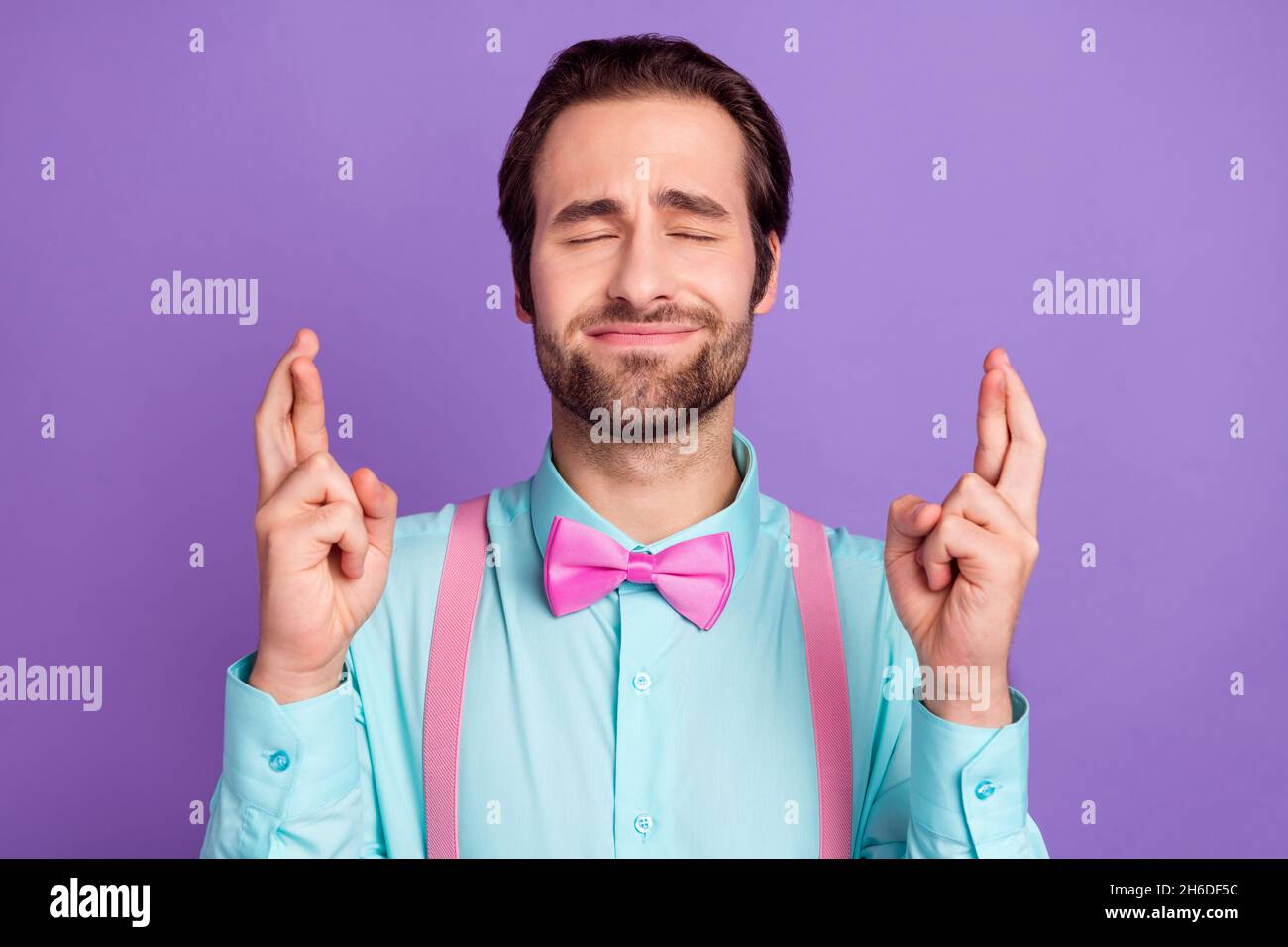 Photo de la question millennal brunet gars croisé doigts porter cravate bretelles chemise bleue isolée sur fond violet Banque D'Images