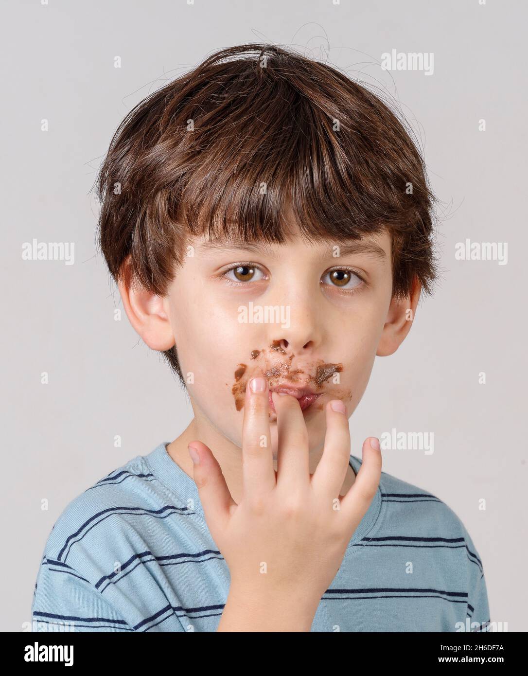 Portrait d'un jeune garçon appréciant sa pâte à tartiner au chocolat Banque D'Images