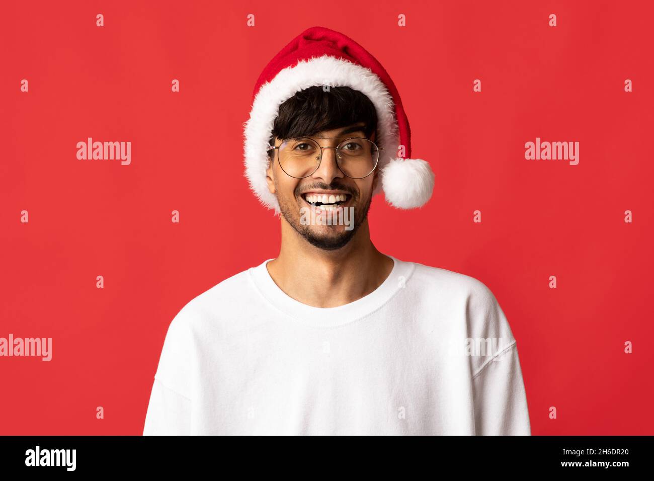 Portrait d'un homme indien charmant et joyeux en chapeau de père Noël Banque D'Images