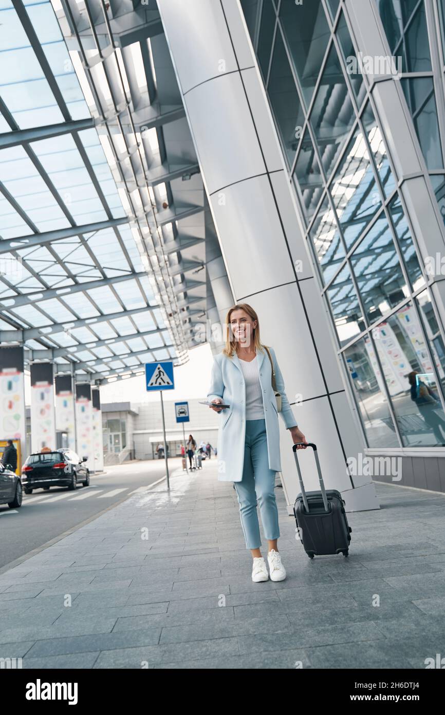 Jeune passager satisfait avec des bagages en vue de la distance Banque D'Images