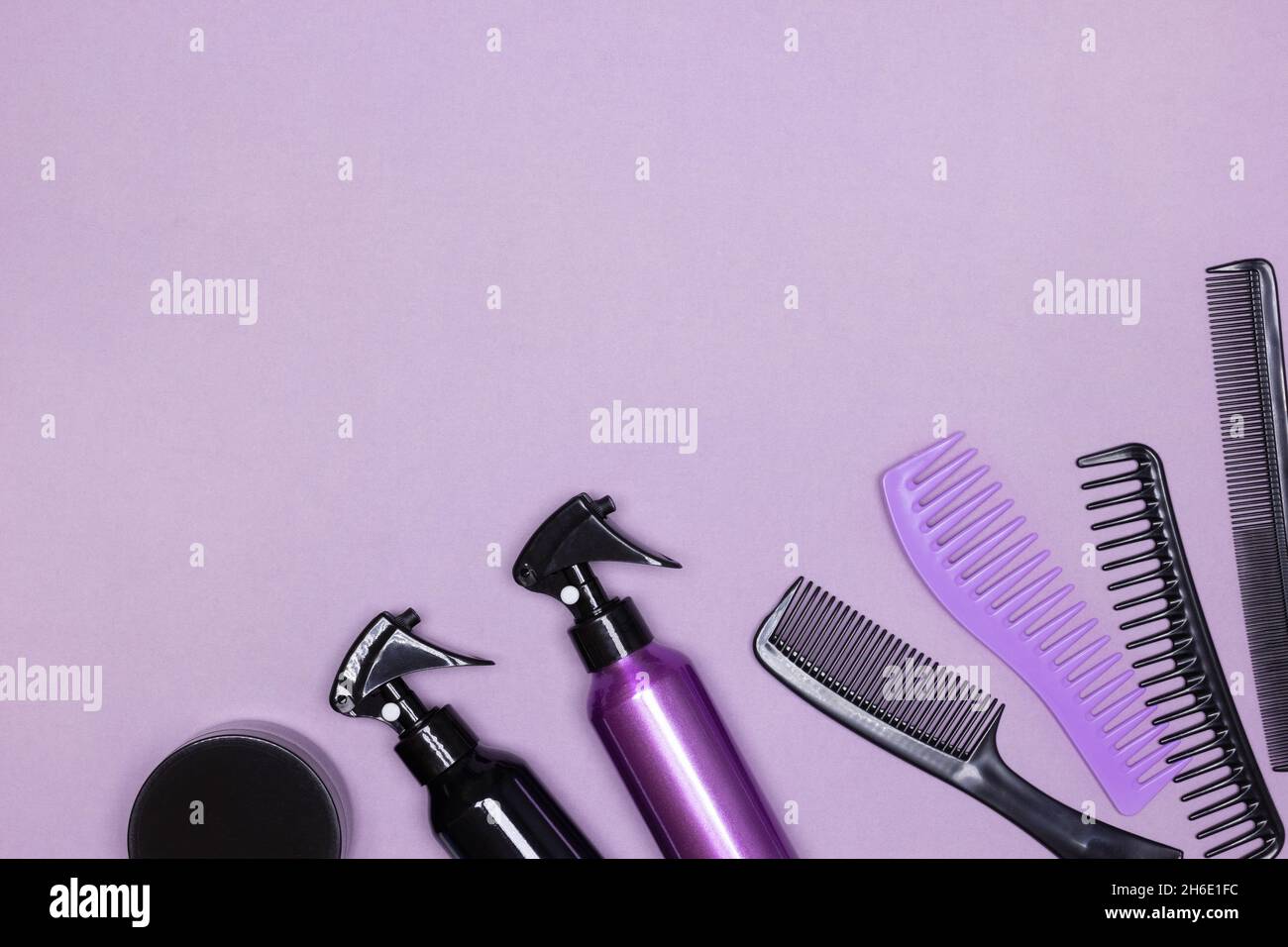 Flacons de produits coiffants avec peignes sur fond violet.Pose à plat.Copier l'espace Banque D'Images