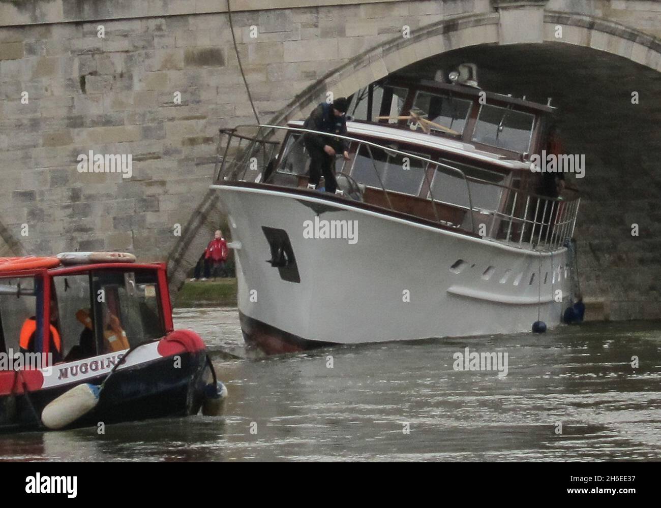 Le skipper d'un croiseur de luxe de 500,000 £ a été laissé à face rouge après qu'il est resté coincé sous un pont sur la Tamise samedi après-midi.Le bateau de 40 pieds de long était trop haut pour traverser le pont Chertsey à Surrey et est devenu coincé sous l'arcade.Le Service d'incendie et de sauvetage de Surrey a déclaré que deux moteurs d'incendie et un bateau d'incendie avaient été envoyés sur les lieux juste avant 13 h 00 GMT le samedi 5 janvier.Il est entendu que l'hespérie avait mal évalué la hauteur de la rivière récemment gonflée par les inondations.Un spectateur a dit, "il n'aurait même pas dû être sur la rivière.Le drapeau rouge n'a pas déclaré les dangers.C'était p Banque D'Images